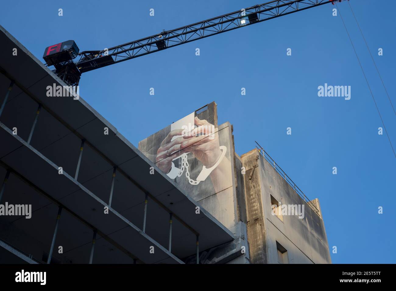 Graffito, das Sklaverei zur Technologie darstellt. Das ehemalige Kaufhausgebäude Karstadt in der Karl-Marx-Straße in Neukölln wird entkuttet und umgebaut. Stockfoto