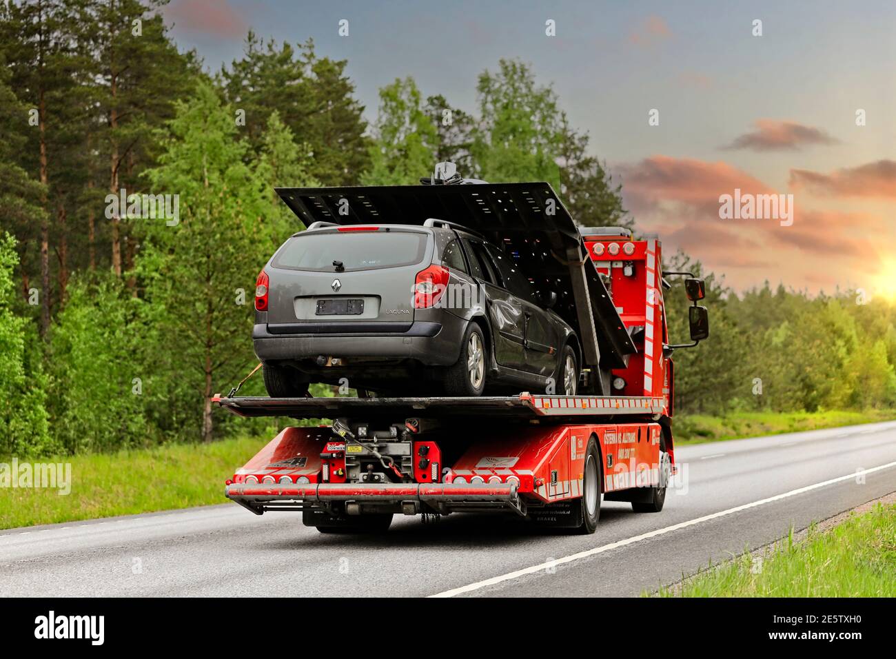 Renault Flachbett Recovery-Fahrzeug von Ostermans ALLTRANS ab Oy trägt beschädigte Auto entlang der Autobahn am Morgen. Raasepori, Finnland. 24.Mai 2019. Stockfoto