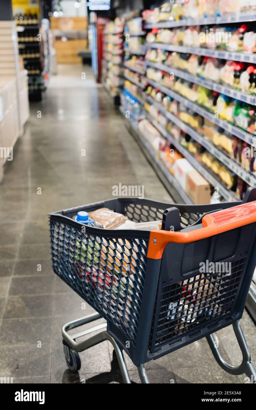 Warenkorb mit Lebensmitteln im Supermarkt auf verschwommenem Hintergrund Stockfoto