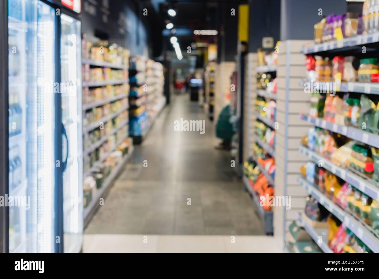 Verschwommener Hintergrund mit Kühlschränken und Lebensmitteln im Supermarkt Stockfoto