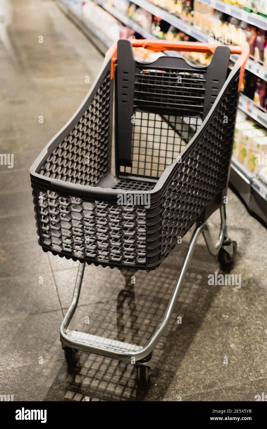 Leerer Warenkorb im Supermarkt auf verschwommenem Hintergrund Stockfoto