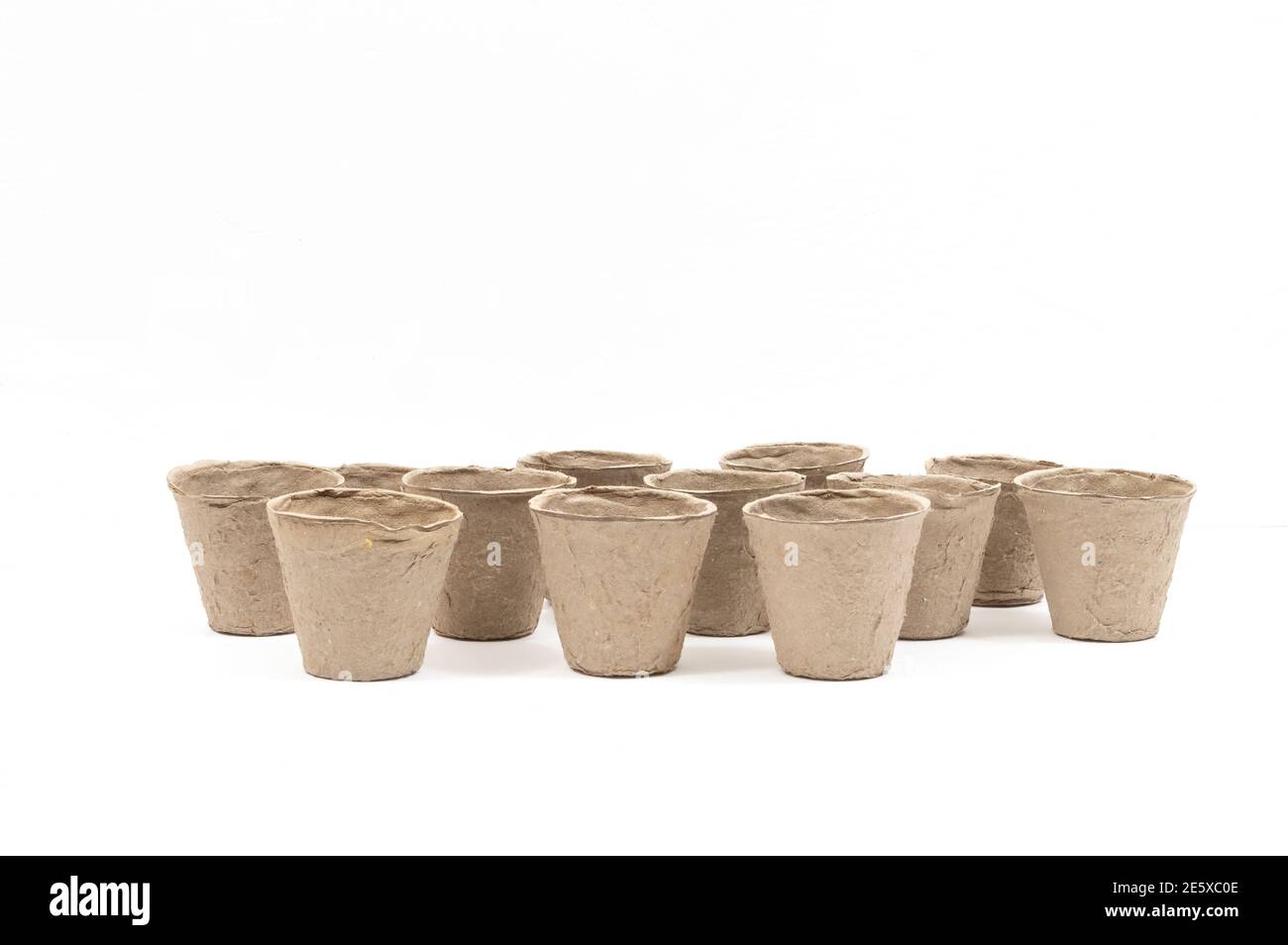Horizontale Aufnahme einer Gruppe biologisch abbaubarer Torftöpfe für die Bepflanzung auf weißem Hintergrund. Viel Kopierplatz. Stockfoto