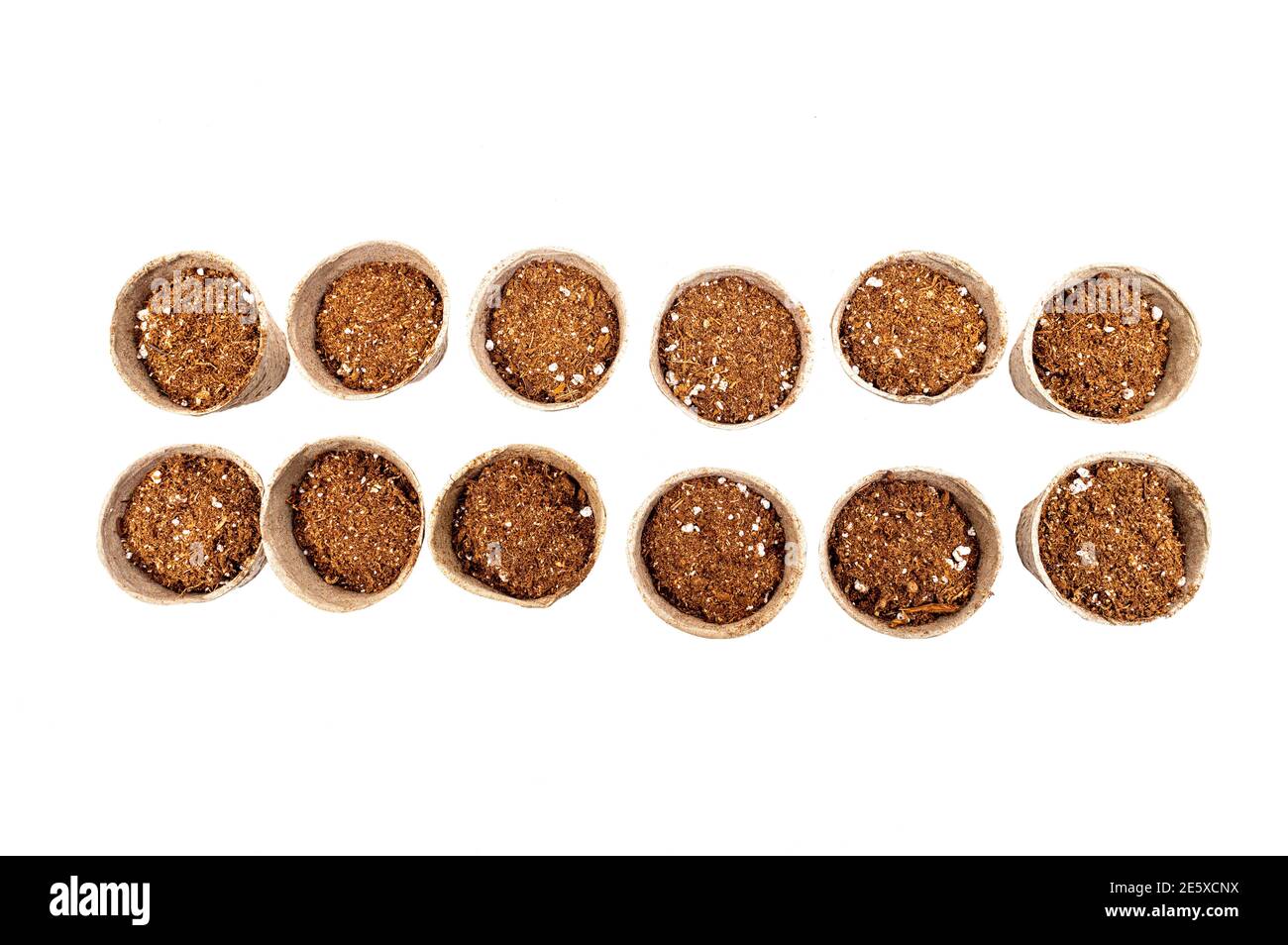 Horizontaler Schuss Blick nach unten auf zwölf biologisch abbaubare Torftöpfe halten Blumenerde auf einem weißen Hintergrund. Stockfoto