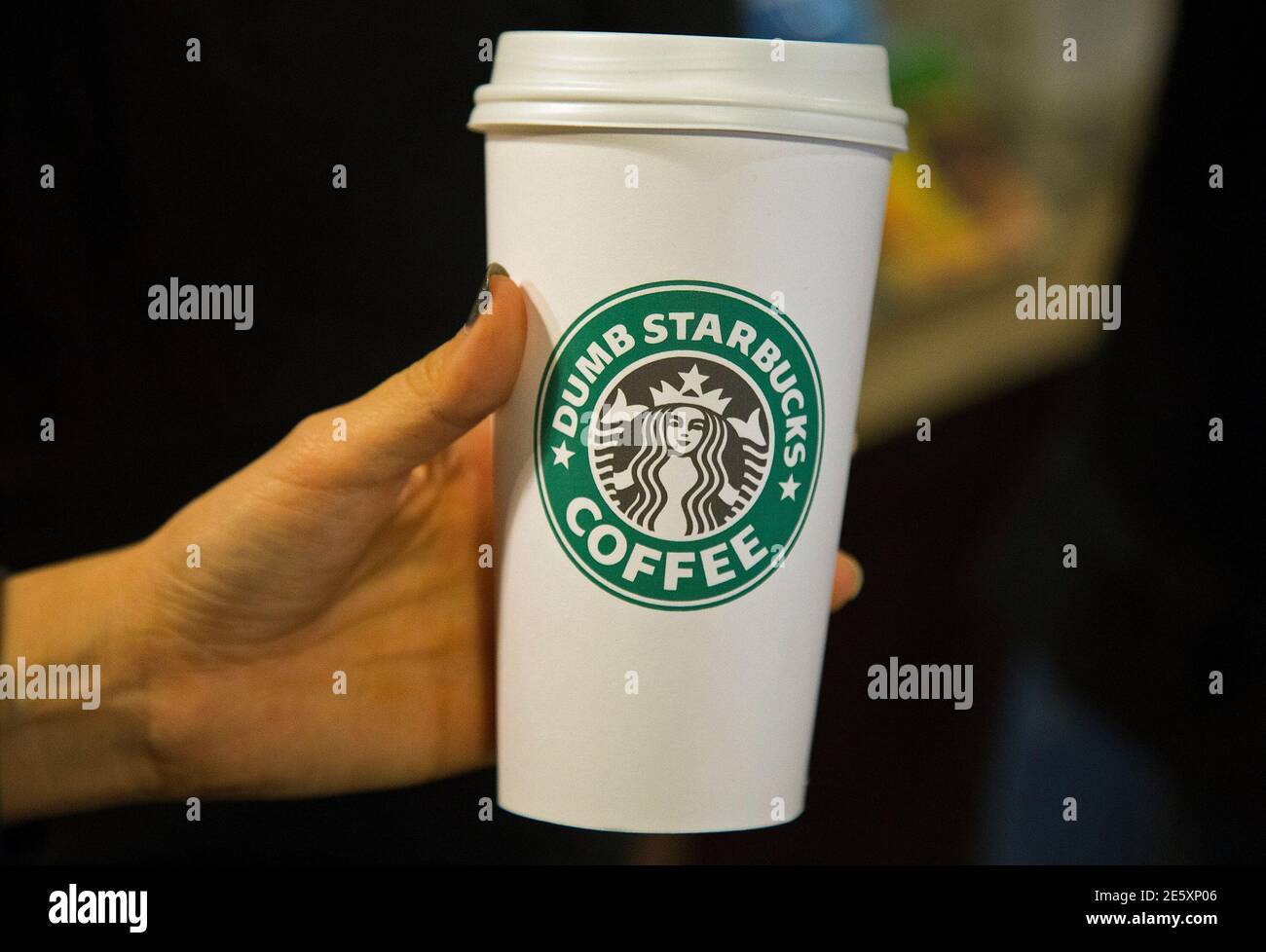 Ein Mann hält einen 'Dumb Starbucks'-Becher in einem Parodie-Laden der  Starbucks Coffee-Kette, in Los Angeles, Kalifornien, am 10. Februar 2014.  Das neue Café "Dumb Starbucks" öffnete am Freitag seine Türen in Los