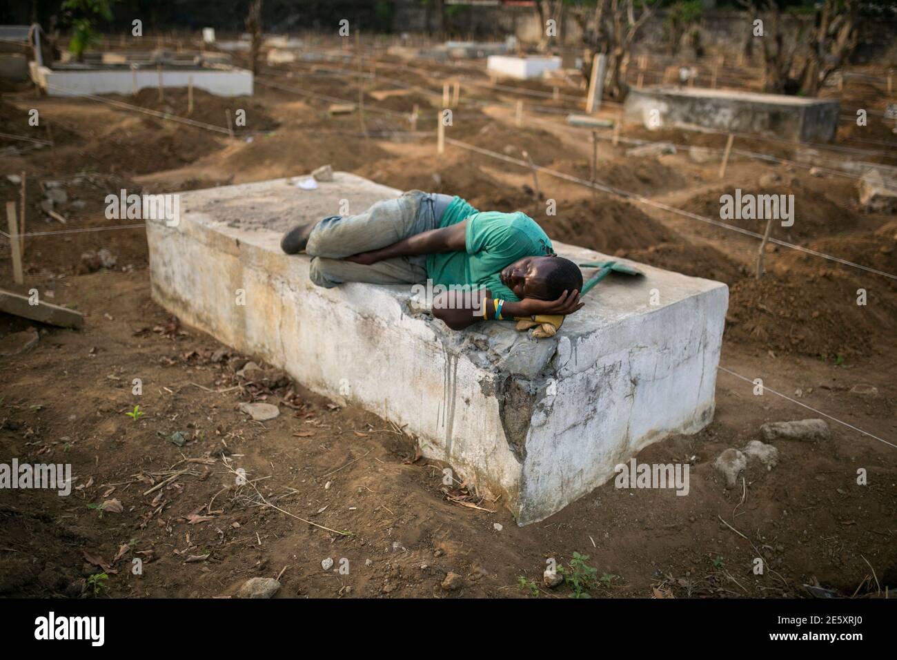Ein Totengraber Schlaft In Der Nahe Der Graber Von Ebola Opfer Auf Einem Friedhof In Freetown 17 Dezember 2014 Die Zahl Der Todesopfer In Der Ebola Epidemie Stieg Auf 6 915 Von 18 603 Fallen