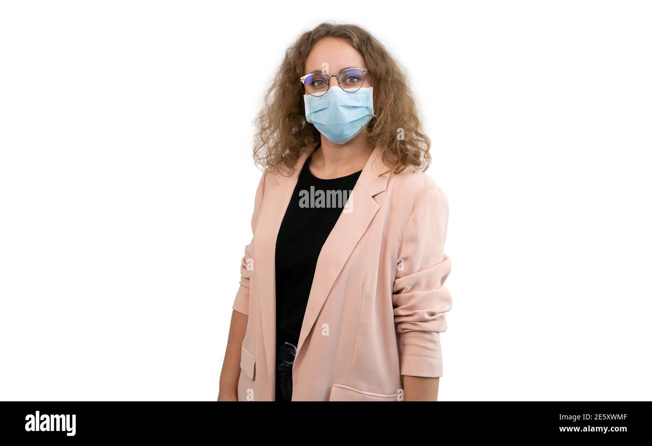 Junge Frau in Anzug trägt Maske und Brille isoliert auf einem weißen. Prävention von Coronavirus oder Covid 19. Stockfoto