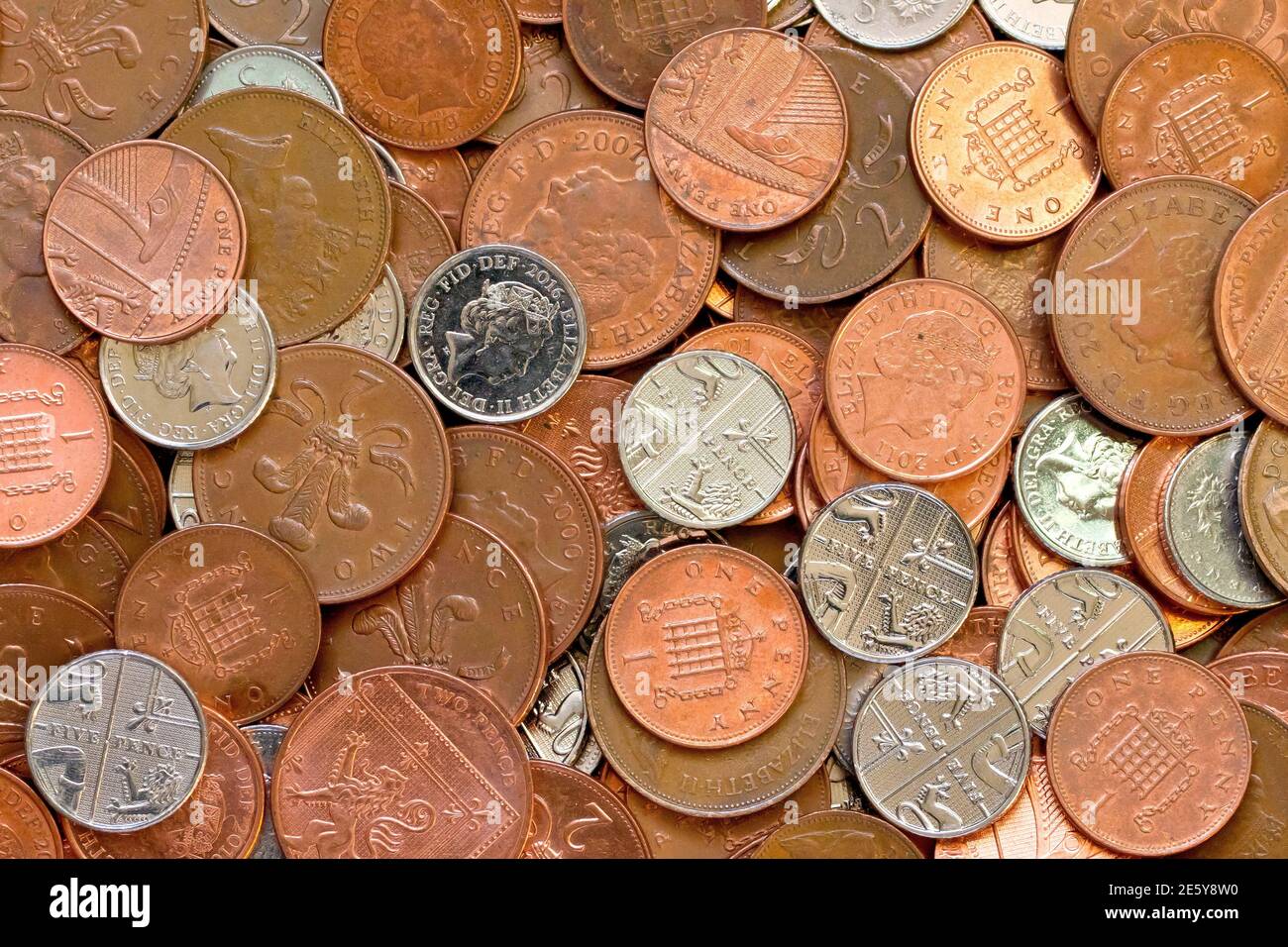 Nahaufnahme einer Sammlung von britischen Dezimalmünzen mit niedriger Stückelung, nämlich Pennies, zwei Pences und fünf Pences. Stockfoto