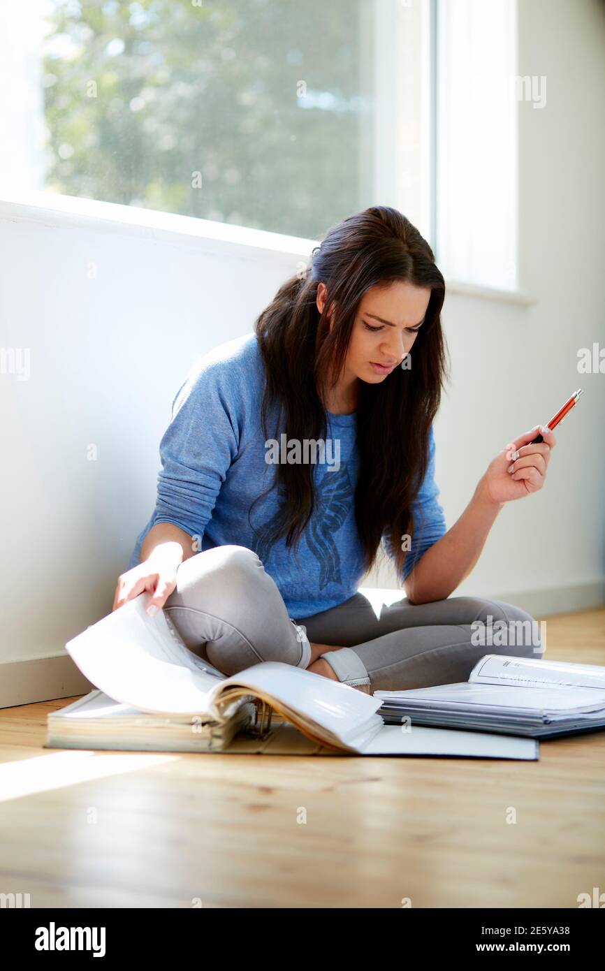 Student Mädchen saß auf dem Boden studieren Stockfoto