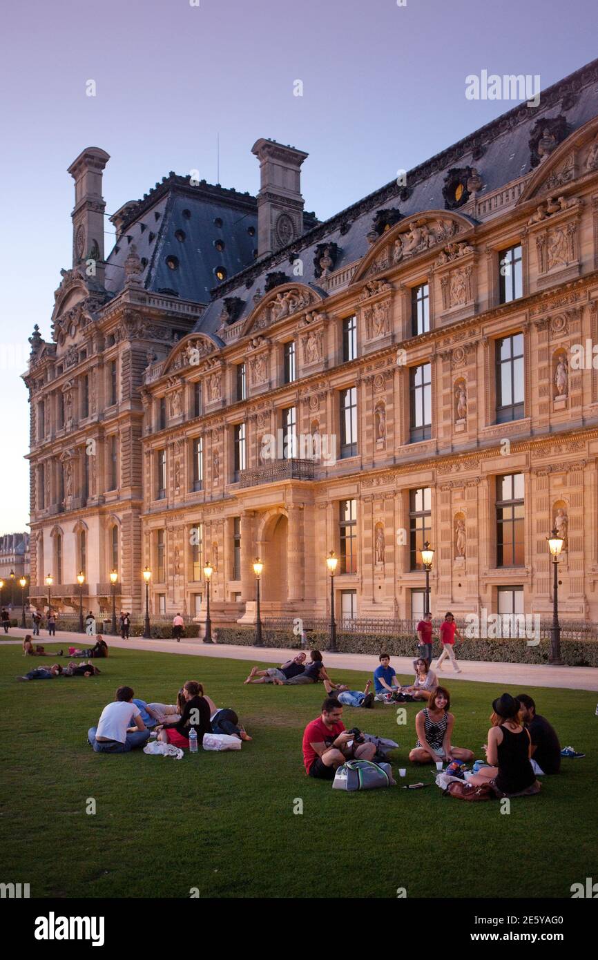 Menschen sitzen im Gras Museum und Bibliothek von dekorativen Kunst in der Nähe von Jardin des Tuileries und Louvers Stockfoto