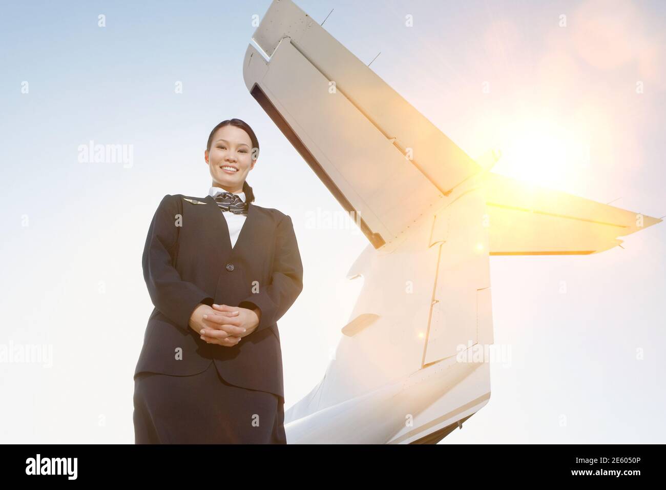 Porträt der Stewardess neben einem Flugzeug Stockfoto
