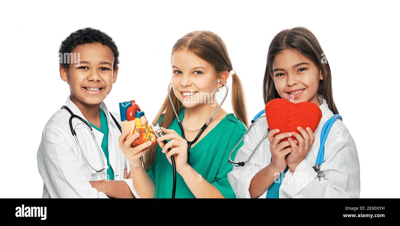 Gruppe positiver multiethnischer Kinder in medizinischen Uniformen und Stethoskopen. Medizinische Versorgung und Betreuung, Konzept des zukünftigen Arztberufs Stockfoto