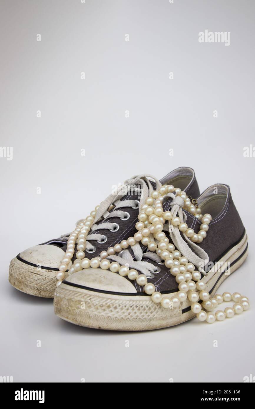 Graue Converse Schuhe mit Perlensträngen Stockfoto