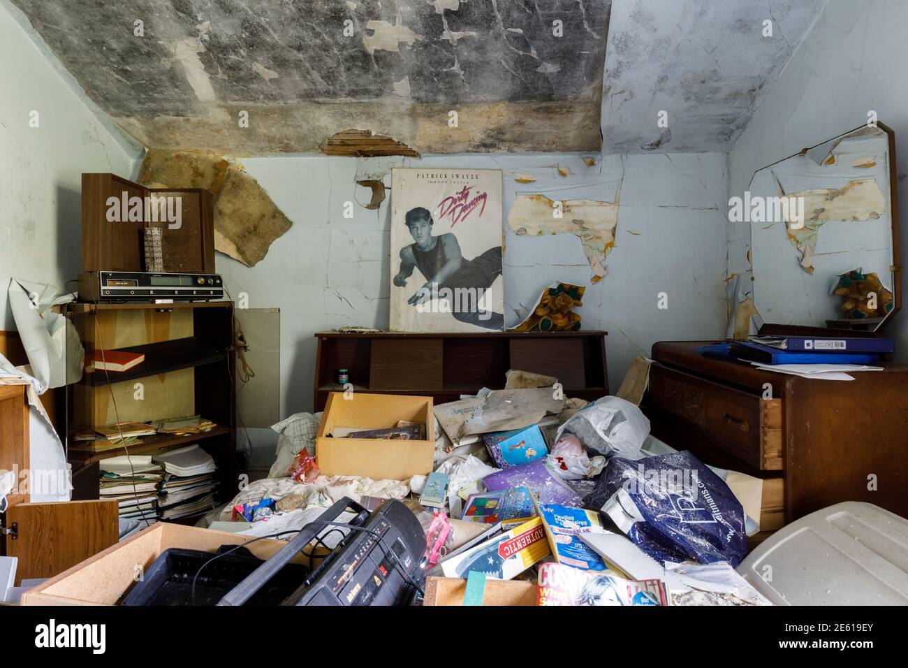 Ein unordentliches Schlafzimmer in einem verlassenen Haus mit einem schmutzigen Tanzposter an der Wand. Ontario, Kanada. Stockfoto