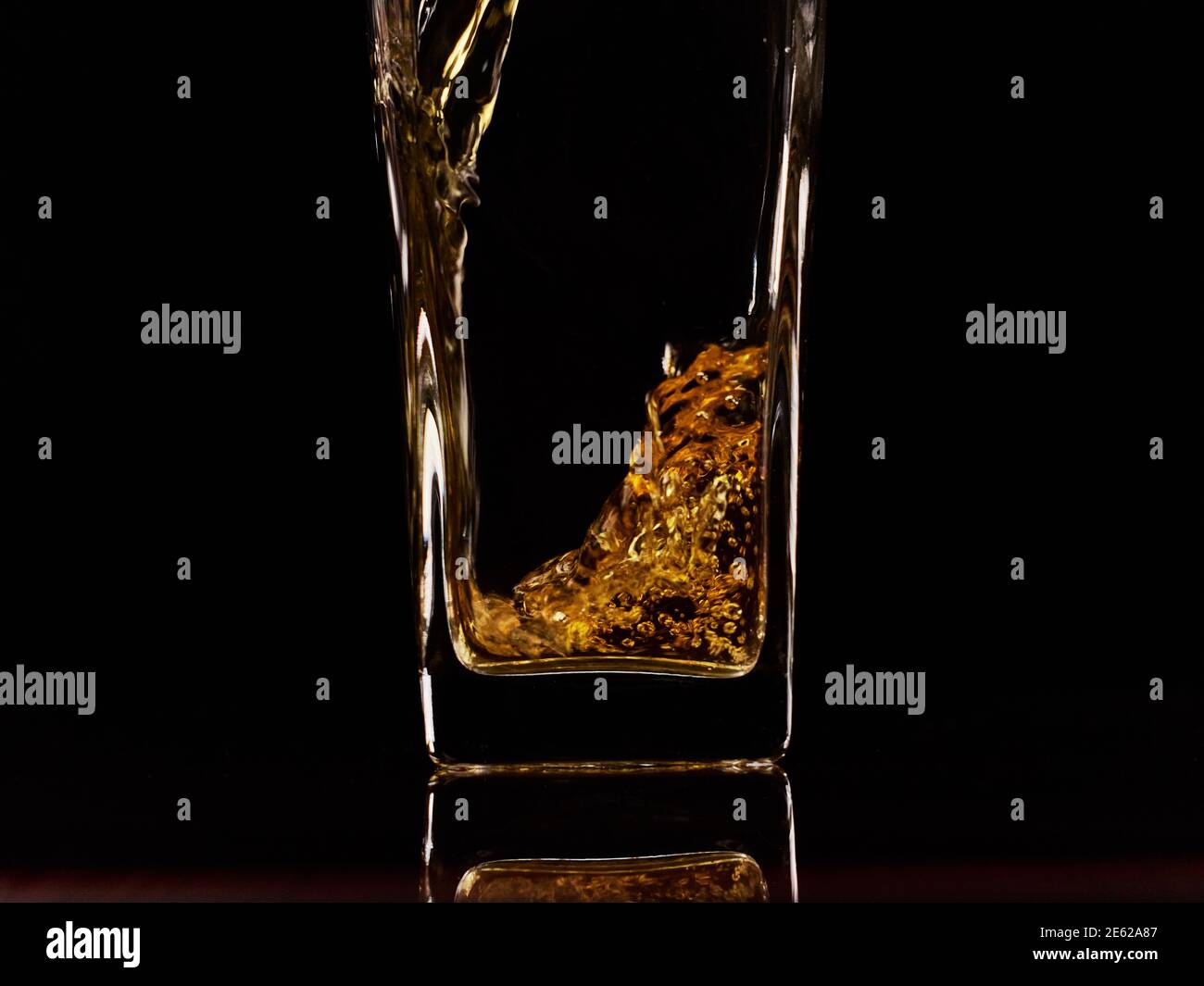 Nahaufnahme des Gießen von frischem Apfelsaft in das Glas. Schwarzer Hintergrund. Zeitlupe. Gesunde Lebensmittel, Vitamine, Früchte Stockfoto
