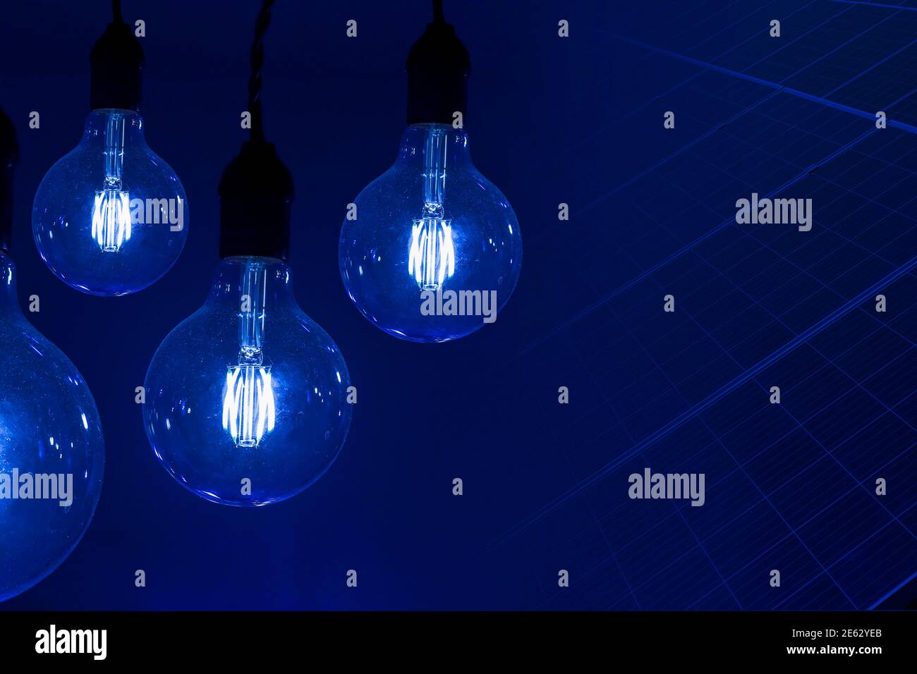 Verschiedene Vintage antike elektrische Lampen vor dunklem Hintergrund und Solar Energiekollektorplatten - Konzept der Ideen Stockfoto