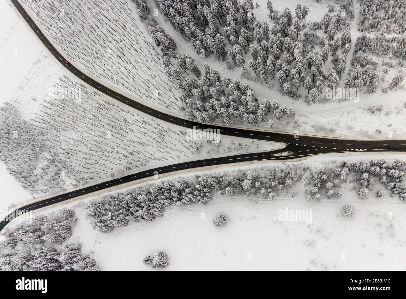 Luftaufnahme der verschneiten Winterlandschaft von Winterberg mit kurvenreichen Straßen und Wegen mit V-förmiger Straßengabel im Sauerland in Nordrhein-Westfalen, Deutschland Stockfoto