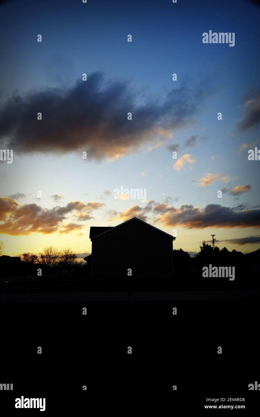 Ein Haus, das gegen den Abendhimmel silhouettiert. Stockfoto