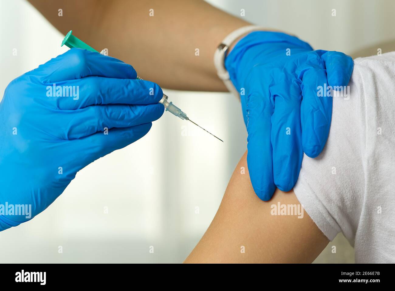 Arzt impft eine Person gegen eine Virusinfektion in einem Krankenhaus Stockfoto