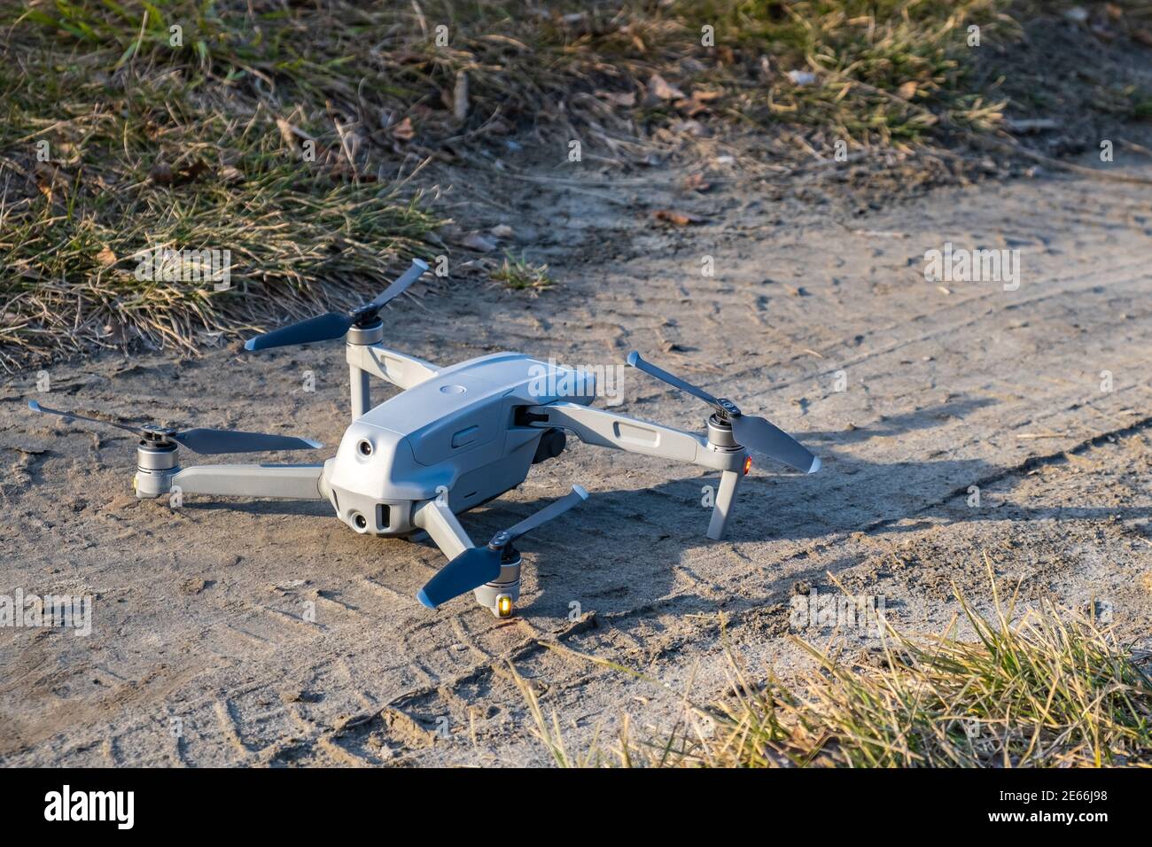 Die Drohne steht auf dem Boden und ist bereit zum Start. Nahaufnahme der montierten grauen Drohne. Fliegende UAV mit einer Hängekamera und Fernbedienung. Stockfoto
