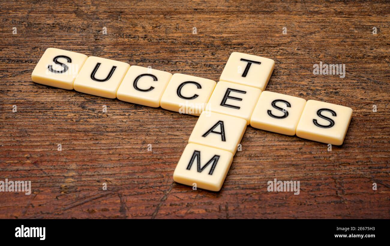 Success Team Kreuzworträtsel in Elfenbein Buchstaben Fliesen gegen rustikal verwittertes Holz, Business und Teamworking Konzept Stockfoto