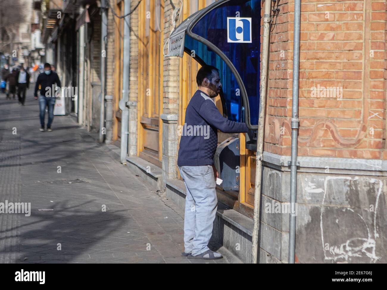 Teheran, Iran. Januar 2021. Ein Mann benutzt den Geldautomaten einer iranischen Bank in Teheran, Iran, 28. Januar 2021. Der Iran erwartet von den Vereinigten Staaten, dass sie die Sanktionen gegen den iranischen Bankensektor "schnell" aufheben, damit er Zugang zu seinen eigenen Vermögenswerten im Ausland hat, um die COVID-19-Epidemie zu bekämpfen, sagte der Sprecher der iranischen Regierung am Dienstag. Quelle: Ahmad Halabisaz/Xinhua/Alamy Live News Stockfoto