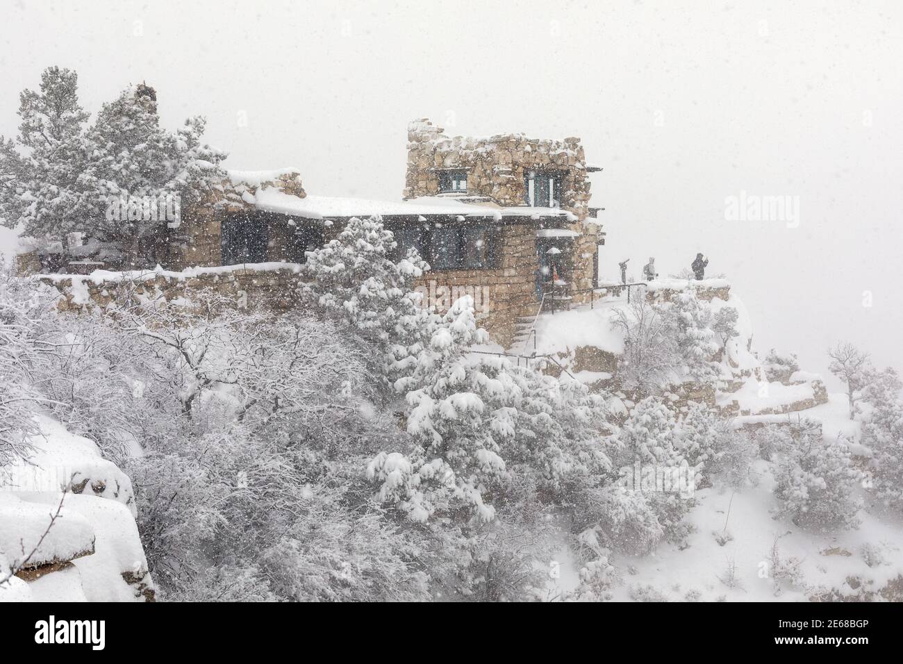 Touristen sehen den Grand Canyon vom Lookout Studio aus während eines Schneesturms im Grand Canyon National Park, Arizona. Stockfoto