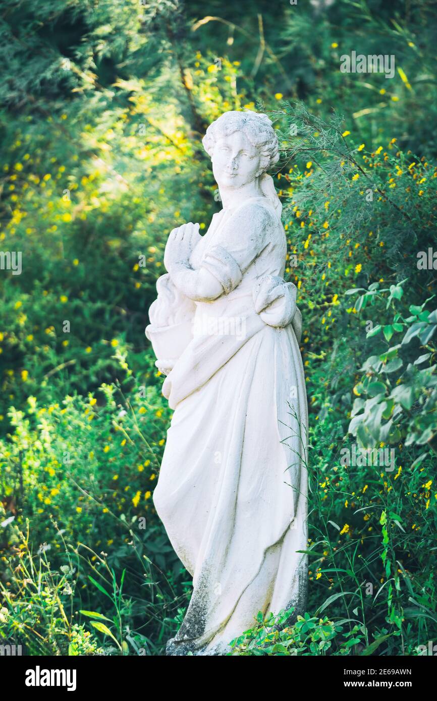 Weiße Marmorskulptur der jungen Frau auf grüner Natur Hintergrund Stockfoto