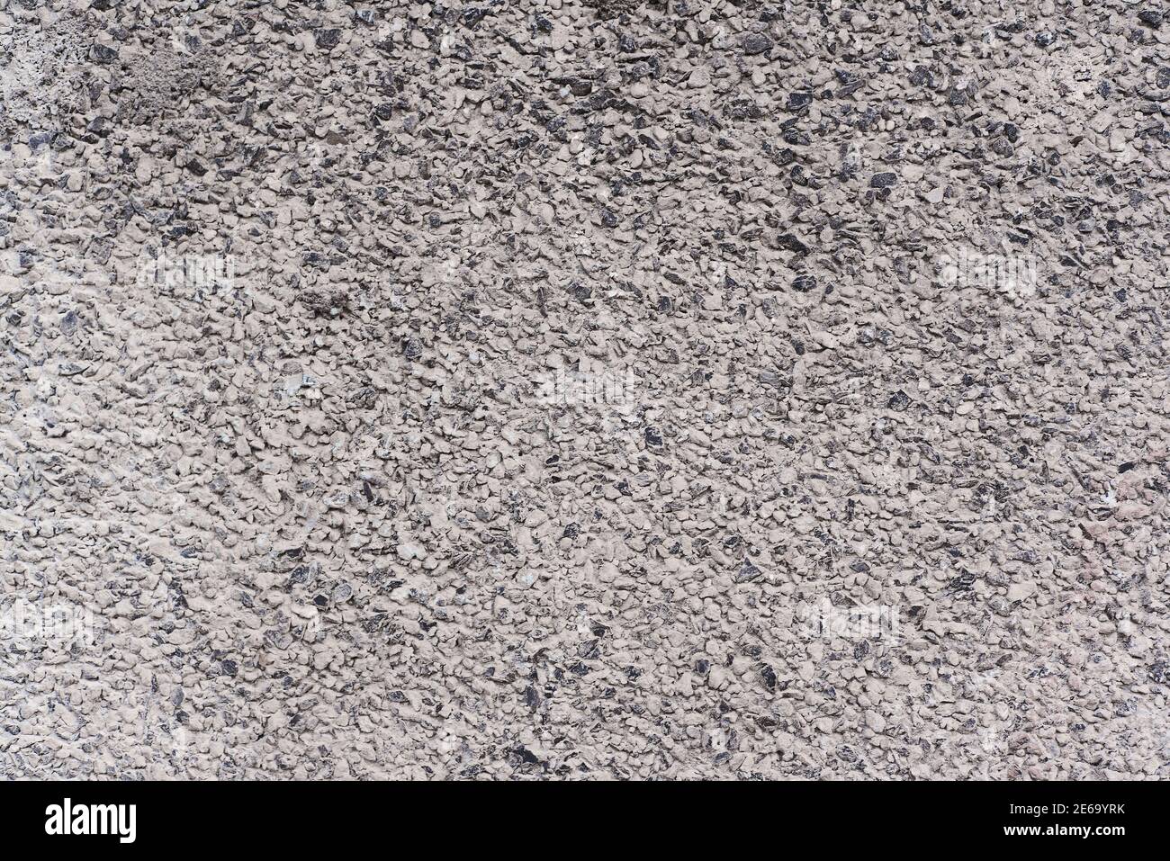 Flache Textur von kleinen grauen und weißen Kieselsteinen Hintergrund Beton Asphaltstraße oder Gebäudewand Oberfläche Stockfoto