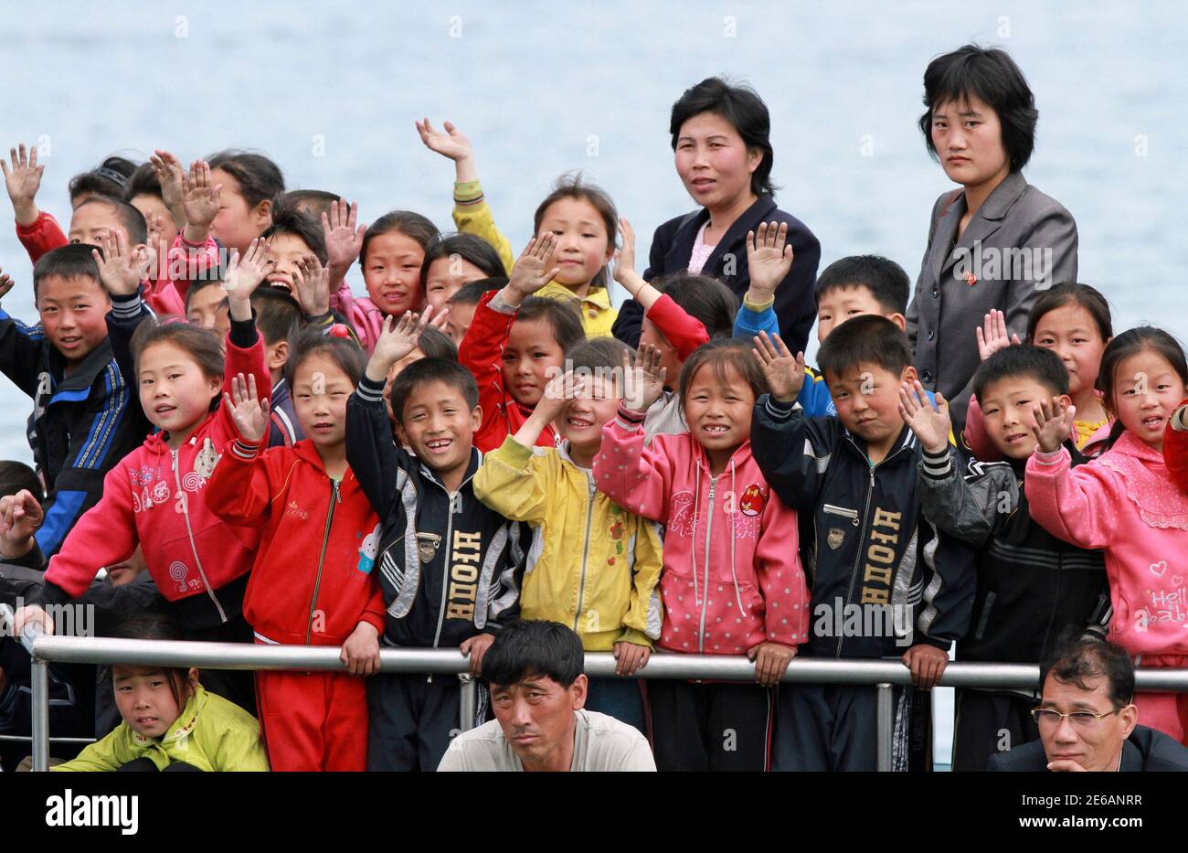 Koreanischen Kinder winken während ihrer Reise am Fluss Yalu in Sinuiju, gegenüber der chinesischen Grenze Stadt Dandong, 15. Mai 2013. REUTERS/Jacky Chen (Nordkorea - Tags: Gesellschaft) Stockfoto