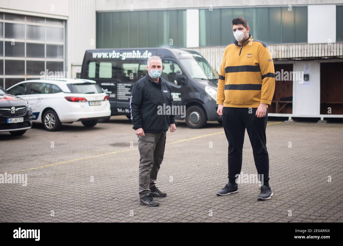 Hannover, Deutschland. Januar 2021. Jannik Könecke (r) und Jörg Vespermann, Fahrlehrer und Geschäftsführer der Berufskraftfahrer-Akademie-Nord GmbH, stehen vor einem für große Lerner umgebauten Fahrzeug. Jannik Könecke ist 2.24 Meter groß und einer der höchsten Deutschen. Um dem 20-Jährigen den Führerschein zu ermöglichen, wurde eigens für ihn ein Van umgebaut. Kredit: Julian Stratenschulte/dpa/Alamy Live Nachrichten Stockfoto