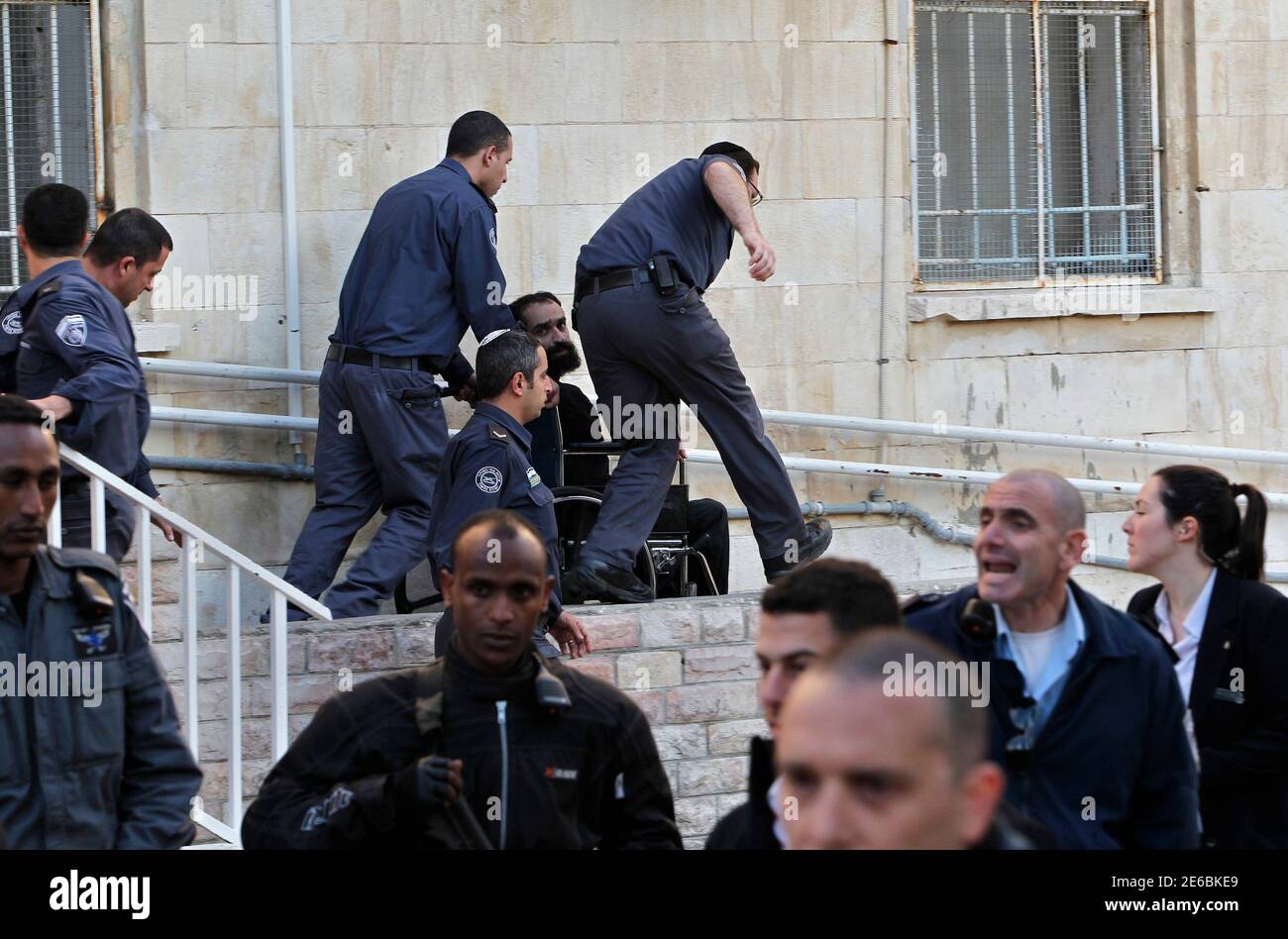 Israelischen Gefängnis schützt Rad Samer al-Issawi, einer der vier Palästinenser durch Israel, eine intermittierende Hungerstreik wurde, gehalten, als er Jerusalem Amtsgericht 19. Februar 2013 geht. Hunderte von palästinensischen Gefangenen in israelischen Gefängnissen erklärte ein eintägiger schnell am Dienstag in Solidarität mit vier Insassen, deren Hungerstreik anti-israelische Proteste im besetzten Westjordanland angeheizt hat. Gaunt und Rollstuhl, Issawi erschien am Dienstag vor dem Zivilgericht Jerusalem, die verzögerte Freigabe ihn für mindestens einen weiteren Monat. REUTERS/Ammar Awad (JERUSALEM - Tags: Politik Unruhen) Stockfoto