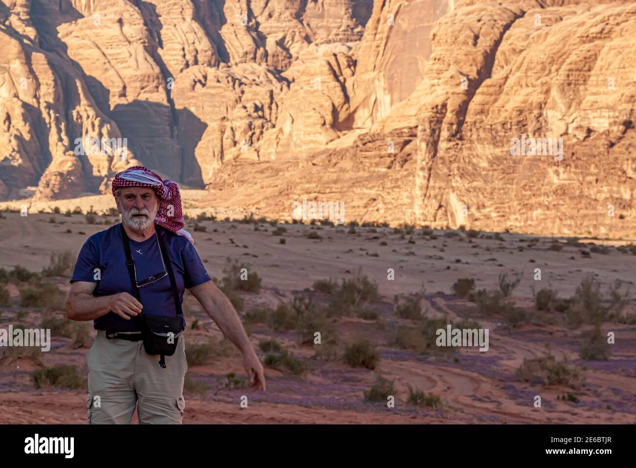 Wadi Rum Desert, Jordanien 03.31.2010: Ein älterer männlicher kaukasischer Tourist, der traditionelle jordanische Keffiyeh-Kopfwickel trägt, wandert allein in der Wüste. Stockfoto