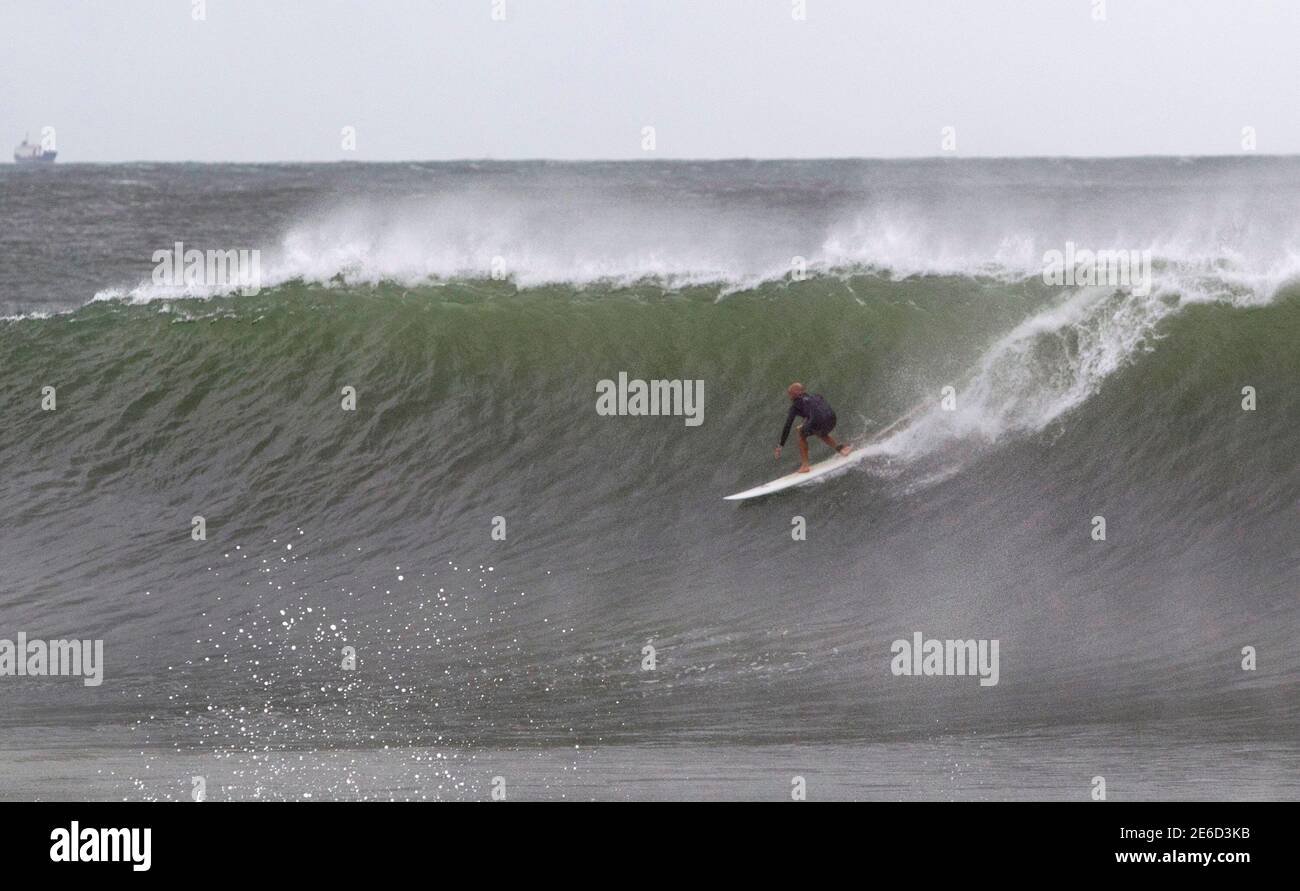 Eine Surfer nutzt große Wellen verursacht durch Hurrikan Irina das einige 200 Seemeilen vor Durban 5. März 2012 sitzt. REUTERS/Rogan Ward (Südafrika - Tags: SPORT Umwelt) Stockfoto