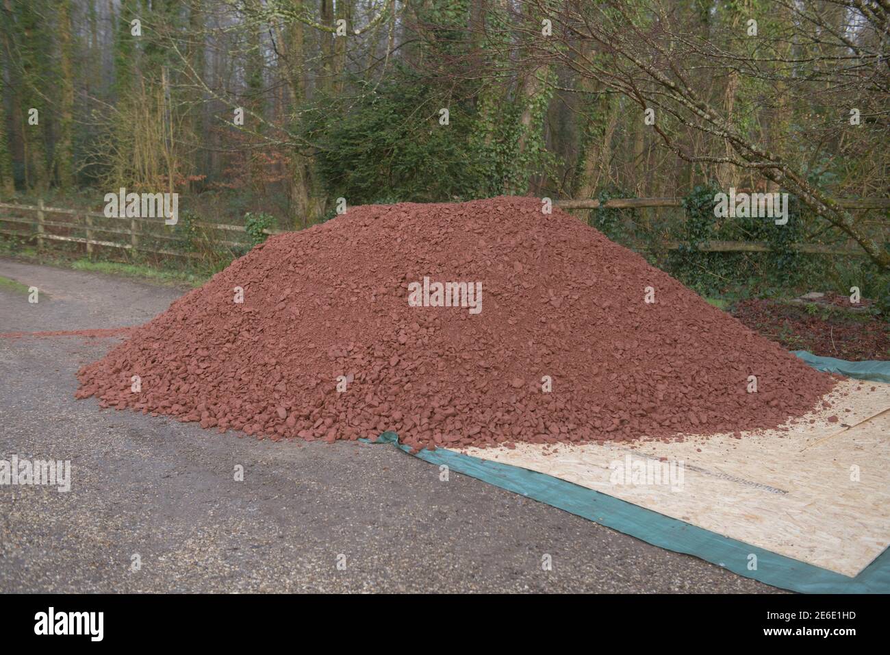 Großer Stapel von Red Stone Scalpings auf dem Drive of a Country Cottage Garden in Rural Devon, England, Großbritannien Stockfoto