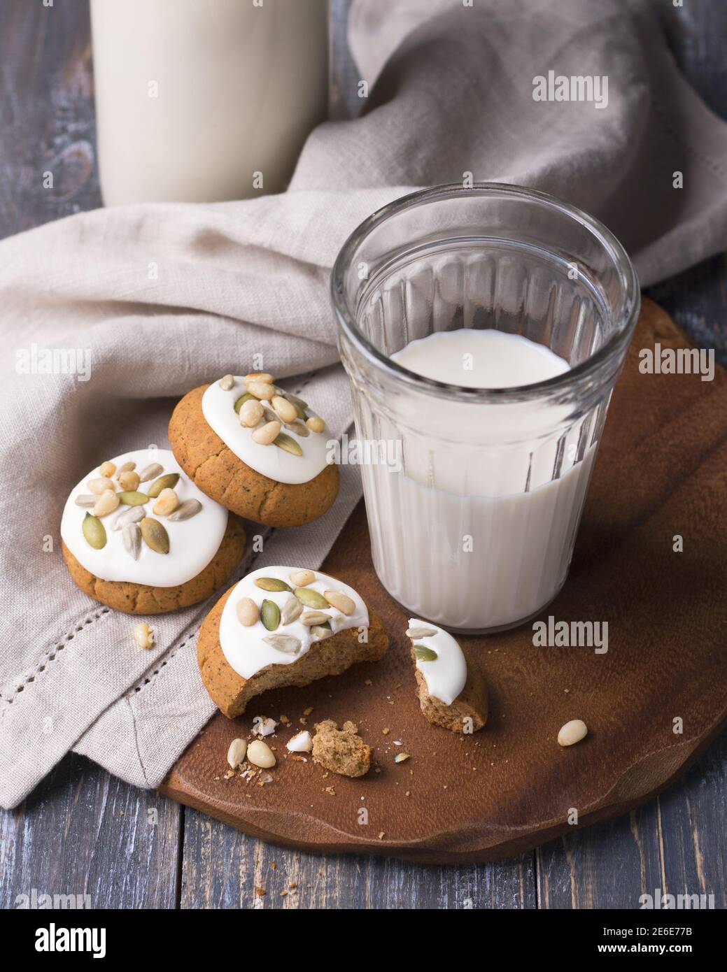 Weihnachts-Lebkuchen mit Nüssen und Samen mit Milch auf einem Holztisch. Köstliche hausgemachte Leckerbissen für Kinder und Weihnachtsmann Stockfoto