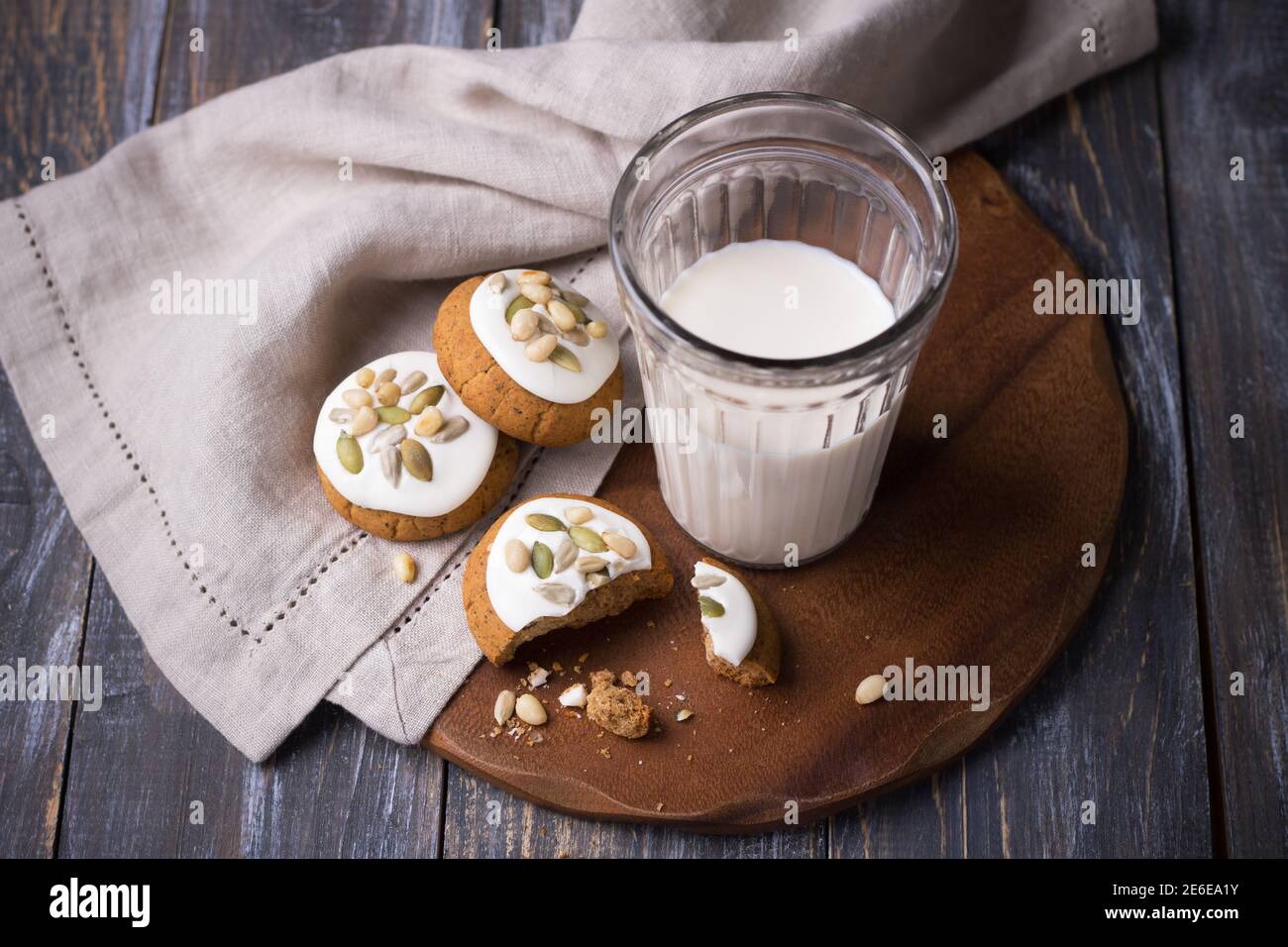 Weihnachts-Lebkuchen mit Nüssen und Samen mit Milch auf einem Holztisch. Köstliche hausgemachte Leckerbissen für Kinder und Weihnachtsmann Stockfoto