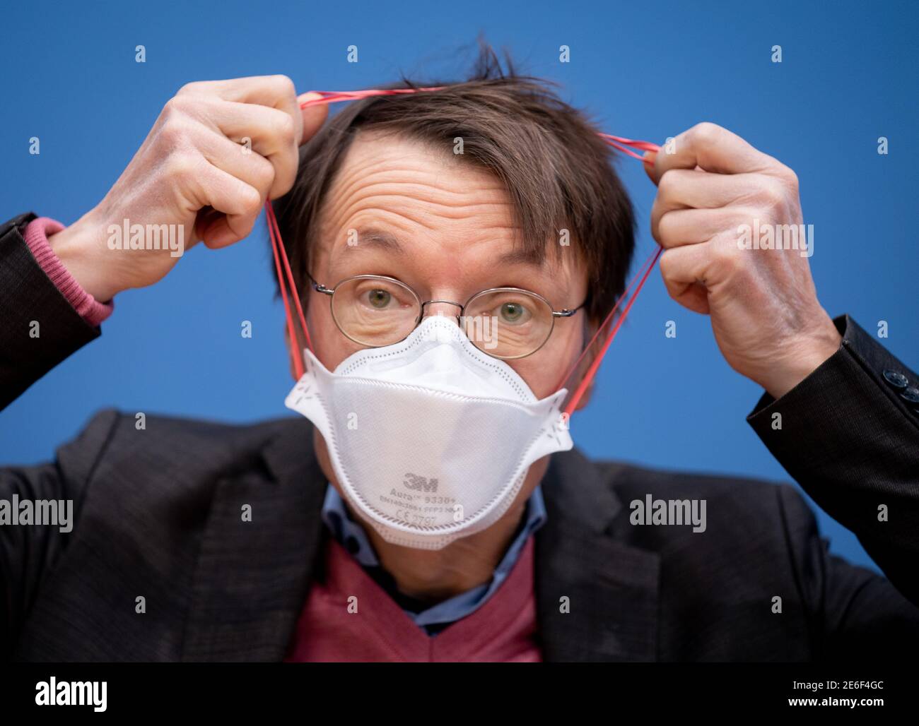 Berlin, Deutschland. Januar 2021. Karl Lauterbach (SPD) hebt zu Beginn der Pressekonferenz der fraktionsübergreifenden Abgeordnetengruppe seine FFP3-Maske ab, um auf der Bundespressekonferenz die Initiative für neue Regelungen zur Euthanasie im Bundestag zu starten. Quelle: Kay Nietfeld/dpa/Alamy Live News Stockfoto