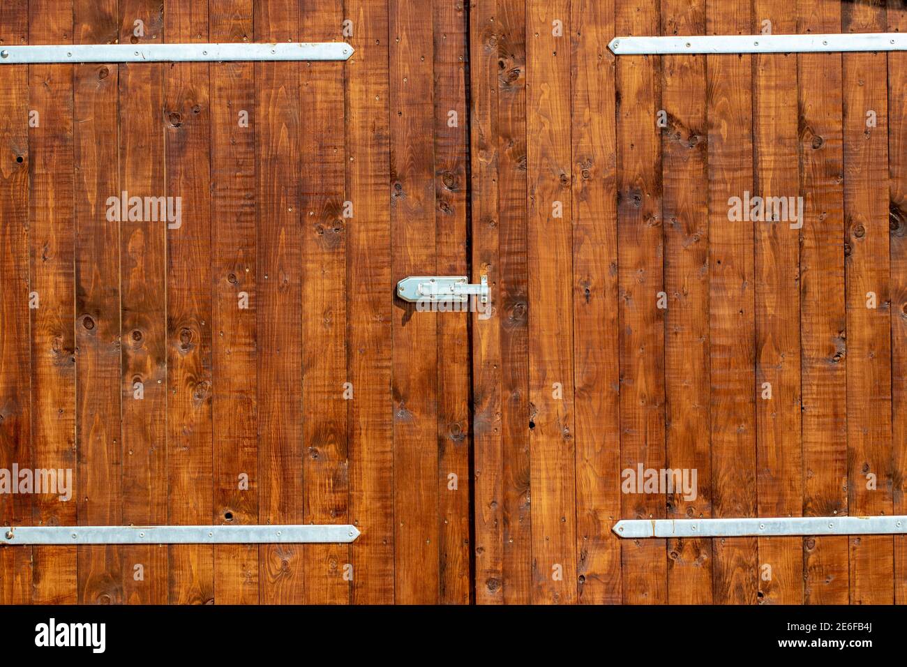 Nahaufnahme einer Holztür mit modernen Scharnieren außerhalb. Stockfoto