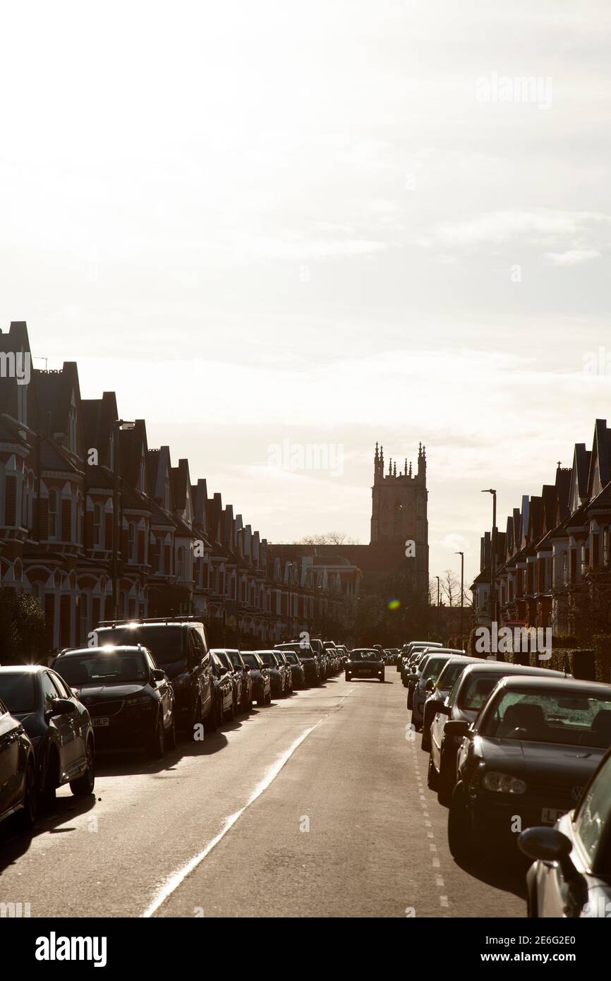 Häuser und St Barnabas Church Silhouette am Ende der Straße, Clapham, London Großbritannien Stockfoto