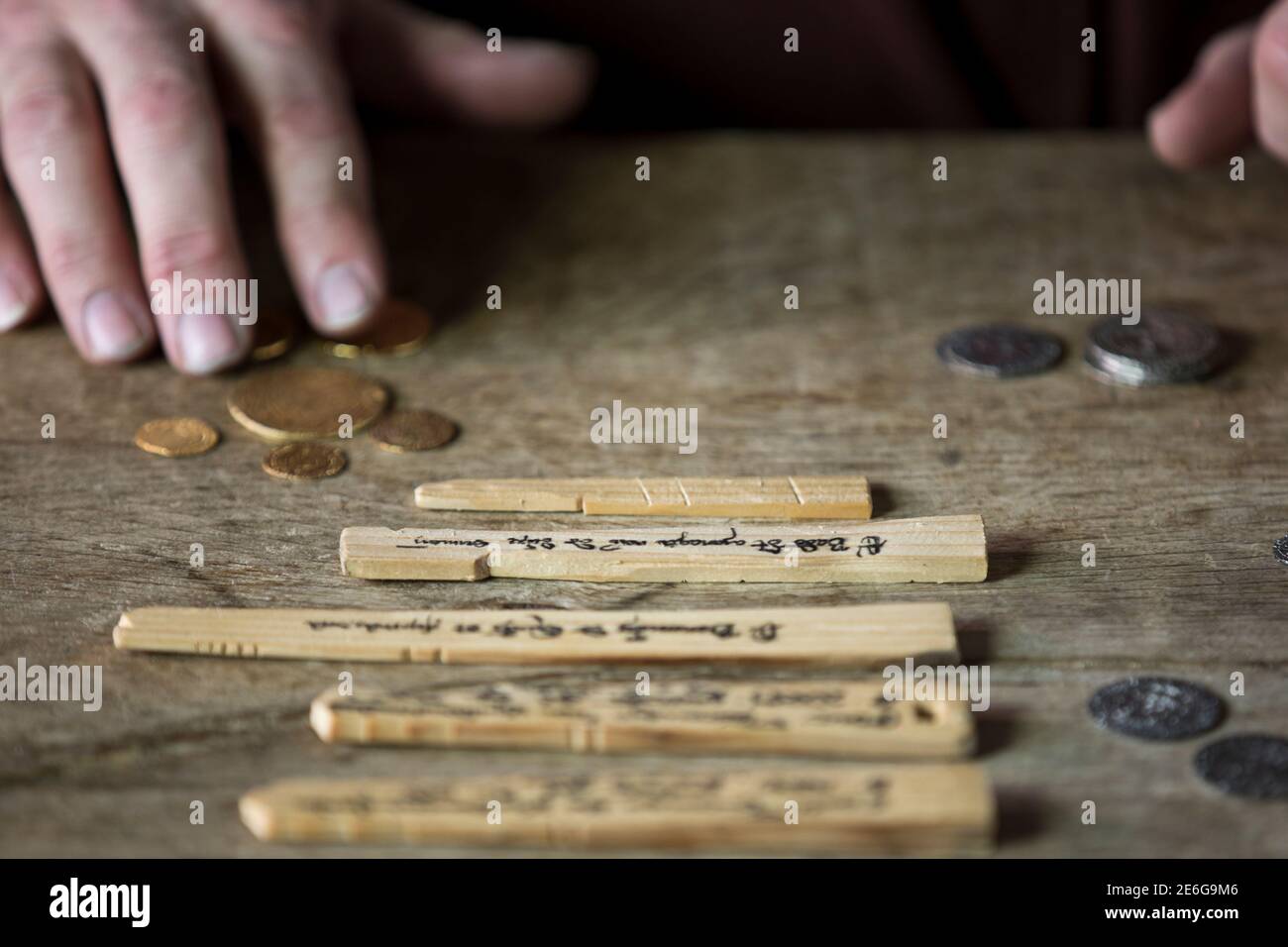 Mittelalterlicher Kaufmann, der Geld mit Tally Sticks zählt Stockfoto