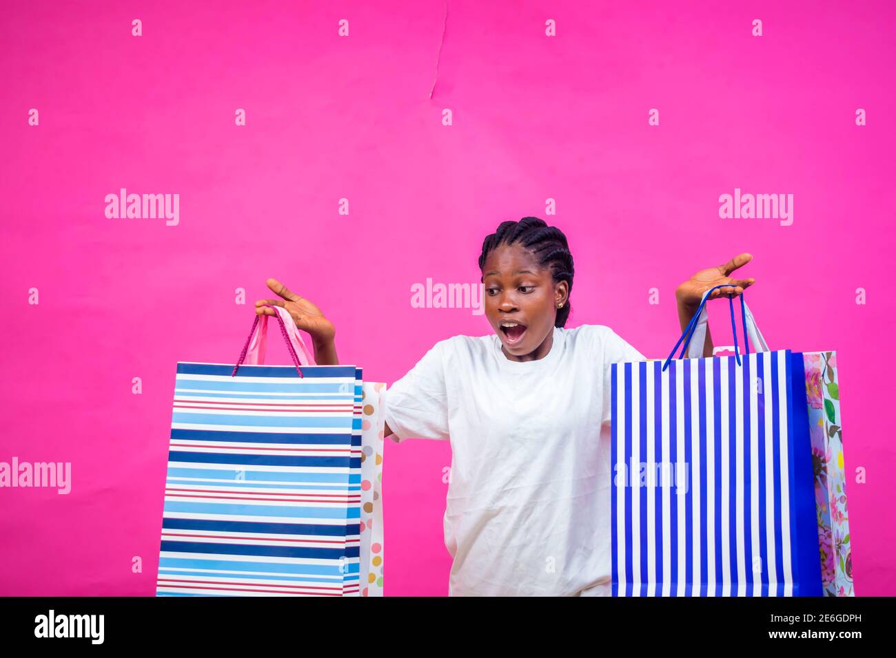 Junge schwarze schöne Dame hält einige Geschenktüten mit einem Schönes Lächeln Stockfoto