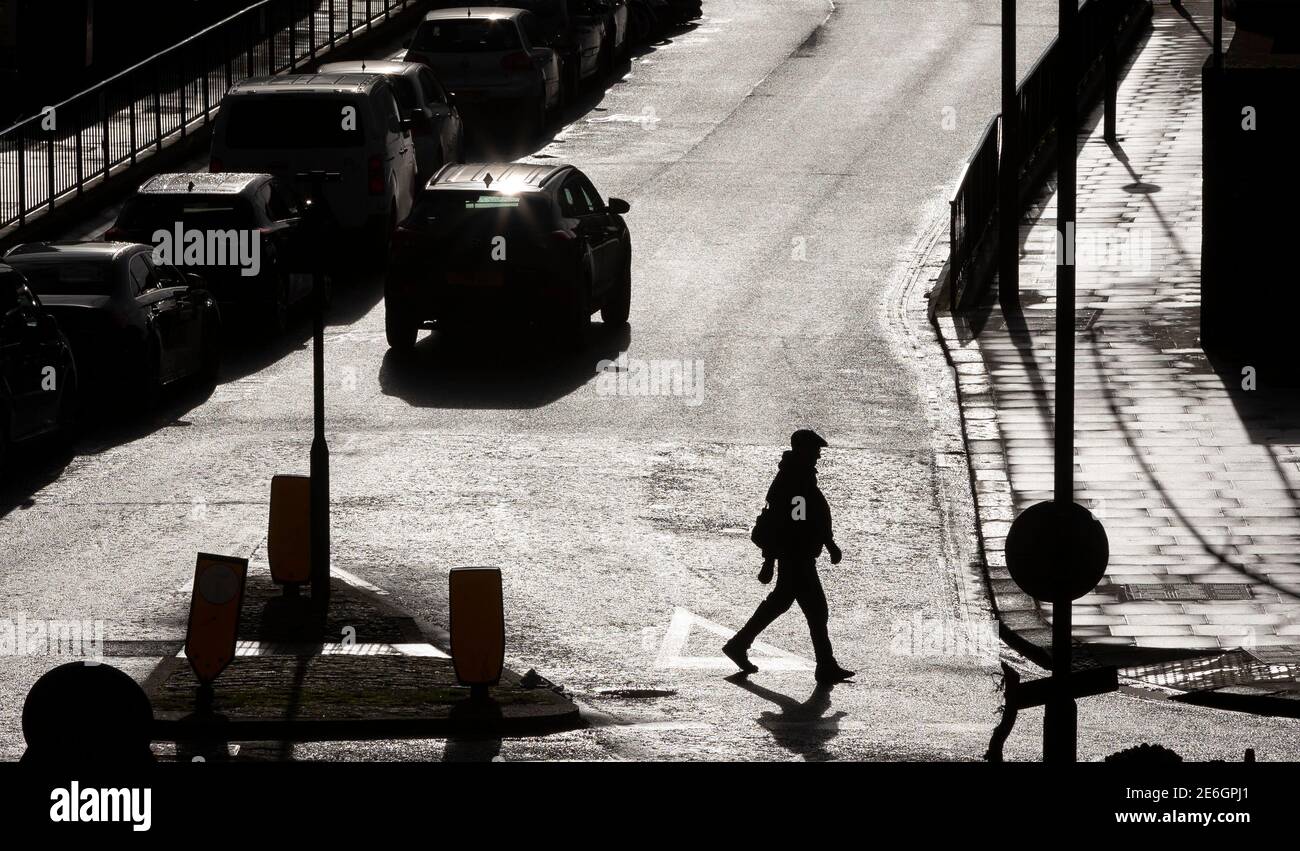 London, Großbritannien. Januar 2021. Ein Fußgänger wird am 28. Januar 2021 in London, Großbritannien, gegen Sonnenschein silhouettiert. Quelle: Han Yan/Xinhua/Alamy Live News Stockfoto