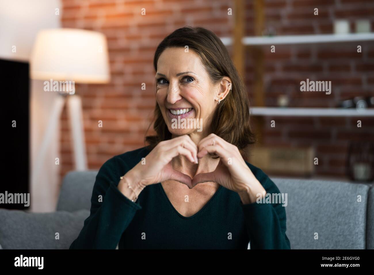 Frau Macht Herz Geste In Video-Telefonkonferenz Stockfoto