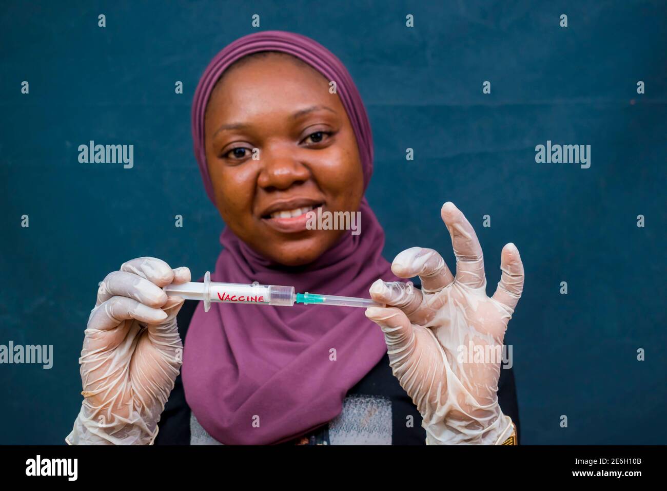 Junge schwarze schöne Dame hält eine Spritze mit dem Impfstoff Einer Pandemie in der IT Stockfoto