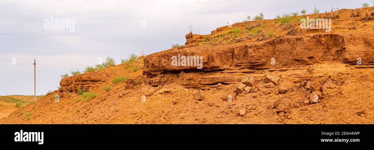 Sandige Klippe mit Schichten von Boden in der Wüste Stockfoto
