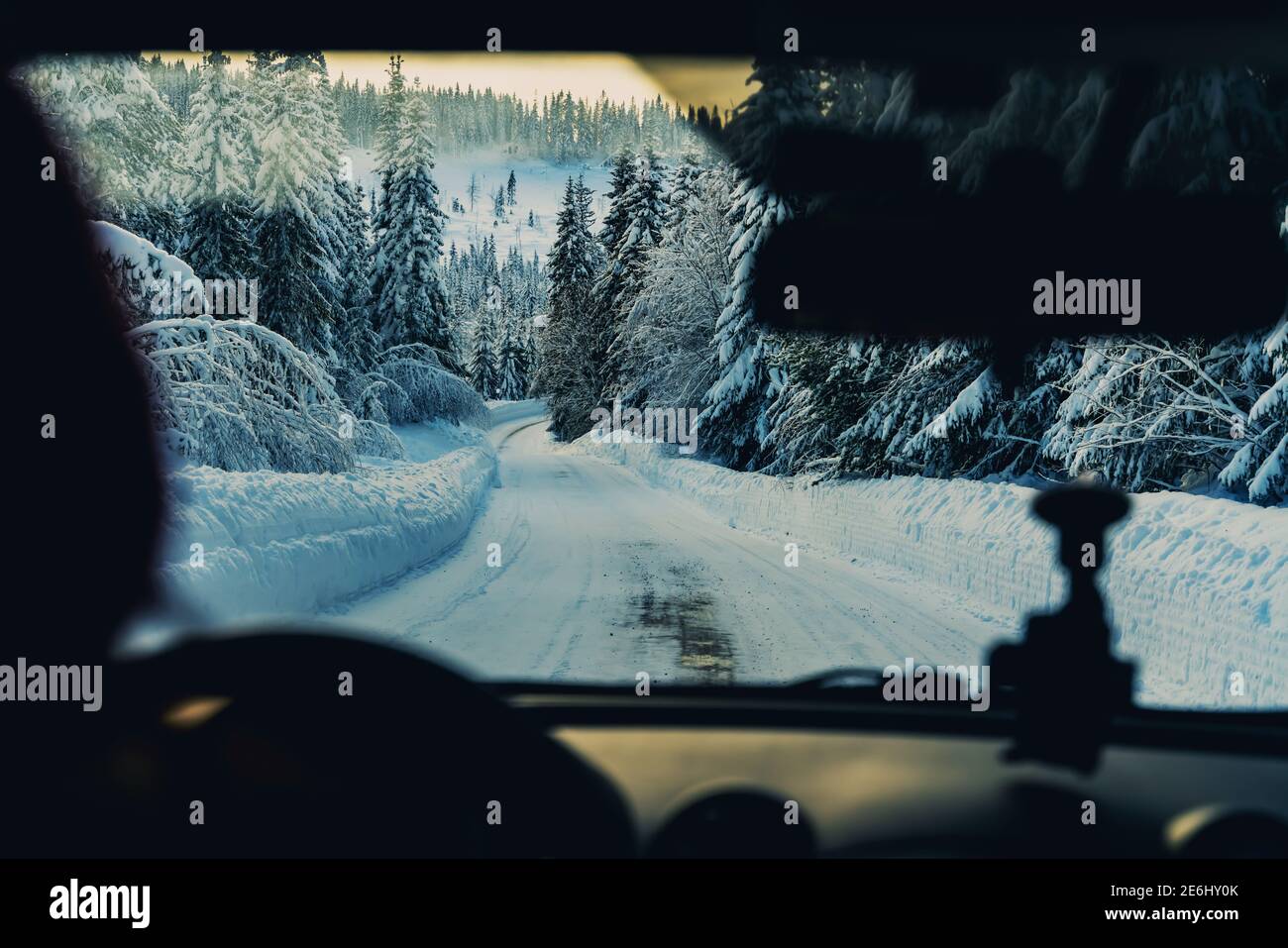 Tauchen auf einer verschneiten Straße durch ein Winterwunderland. Fahrersicht. Stockfoto
