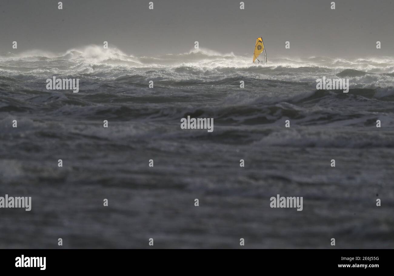 Ein Windsurfer surft im rauen Meer vor dem West Wittering Strand in West Sussex. Bilddatum: Freitag, 29. Januar 2021. Stockfoto