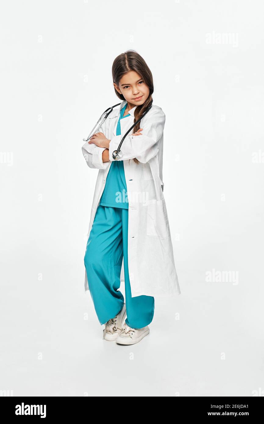 Mixed-Rennen-Mädchen trägt ein medizinisches Outfit mit einem ernsten Gesicht, Blick auf die Kamera. Isoliert auf weißem Hintergrund Stockfoto