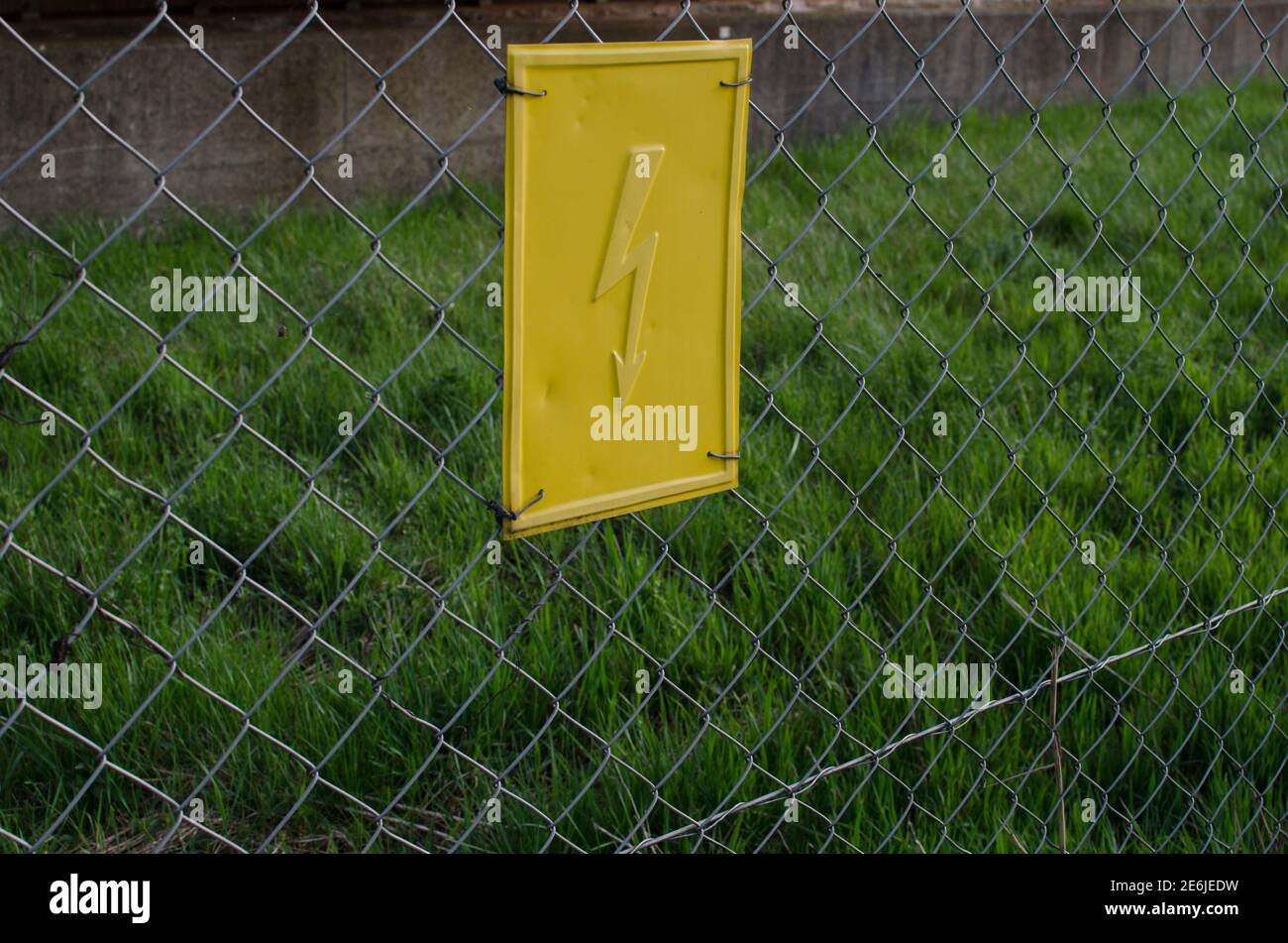 schild mit Vorsicht Strom auf einem Zaun Stockfoto