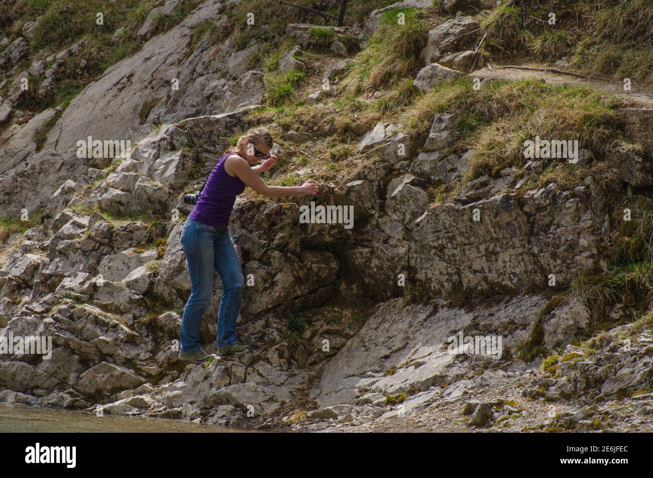 Junge Frau beim Klettern am See Stockfoto